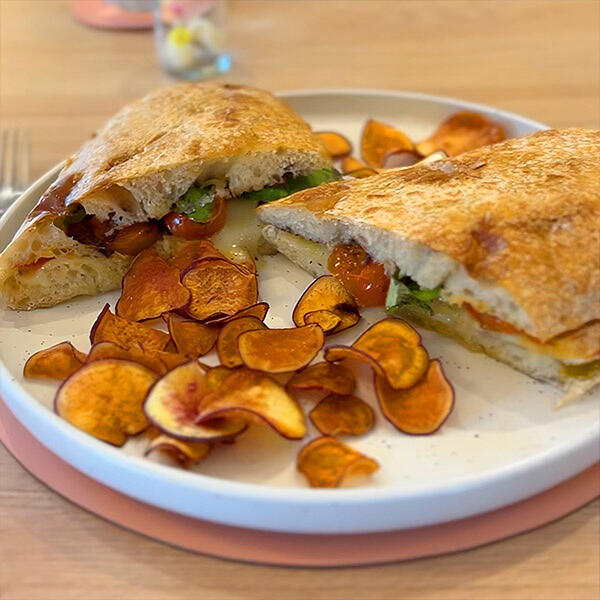 CIABATTA CAPRESE / muzarella, tomates confitados, albahaca fresca, aceitunas negras, chips / $9990