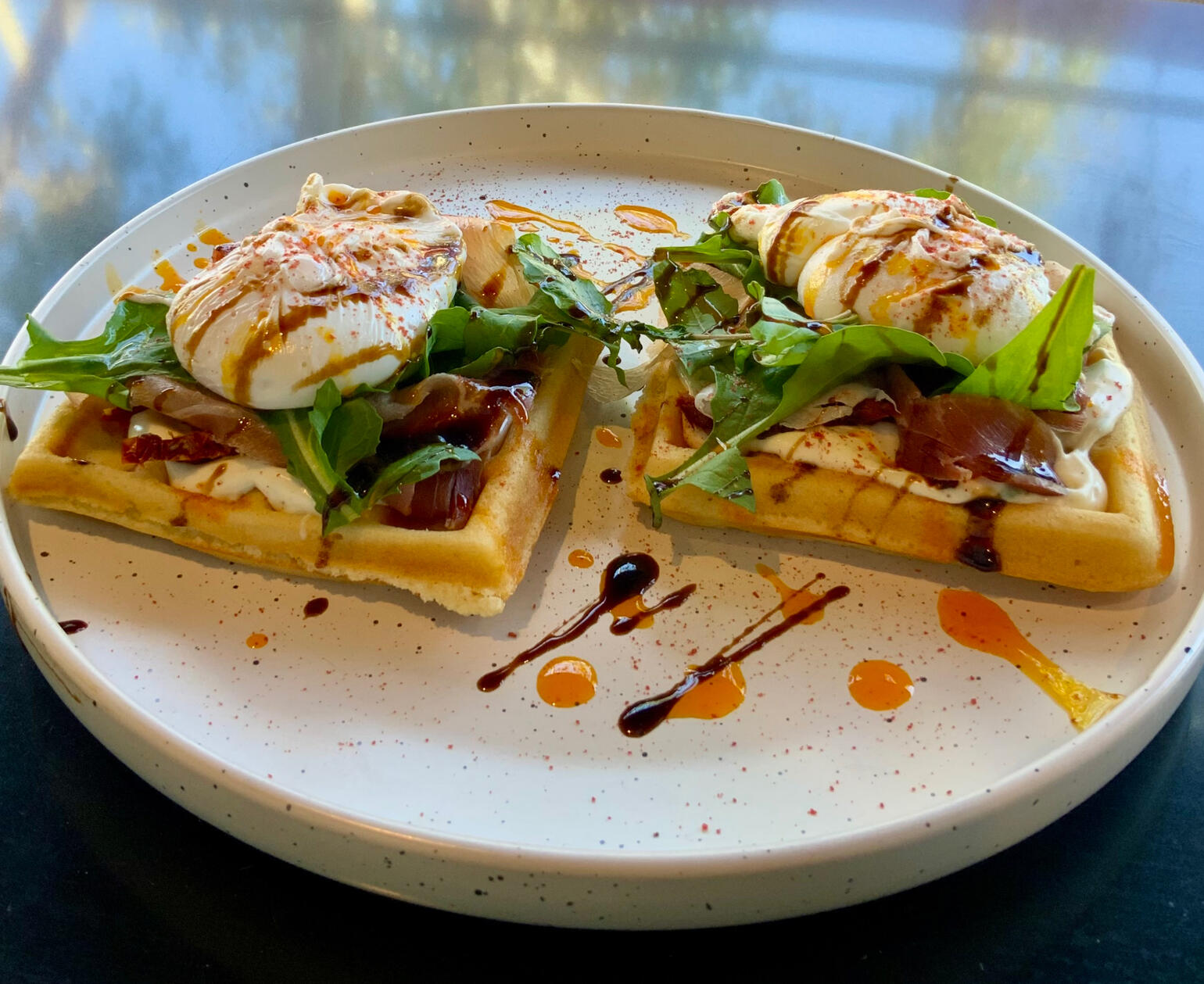 WAFFLES BAJO TERRA / queso crema, panceta, tomates deshidratados, rucula, aceto y huevos poche / $9500
