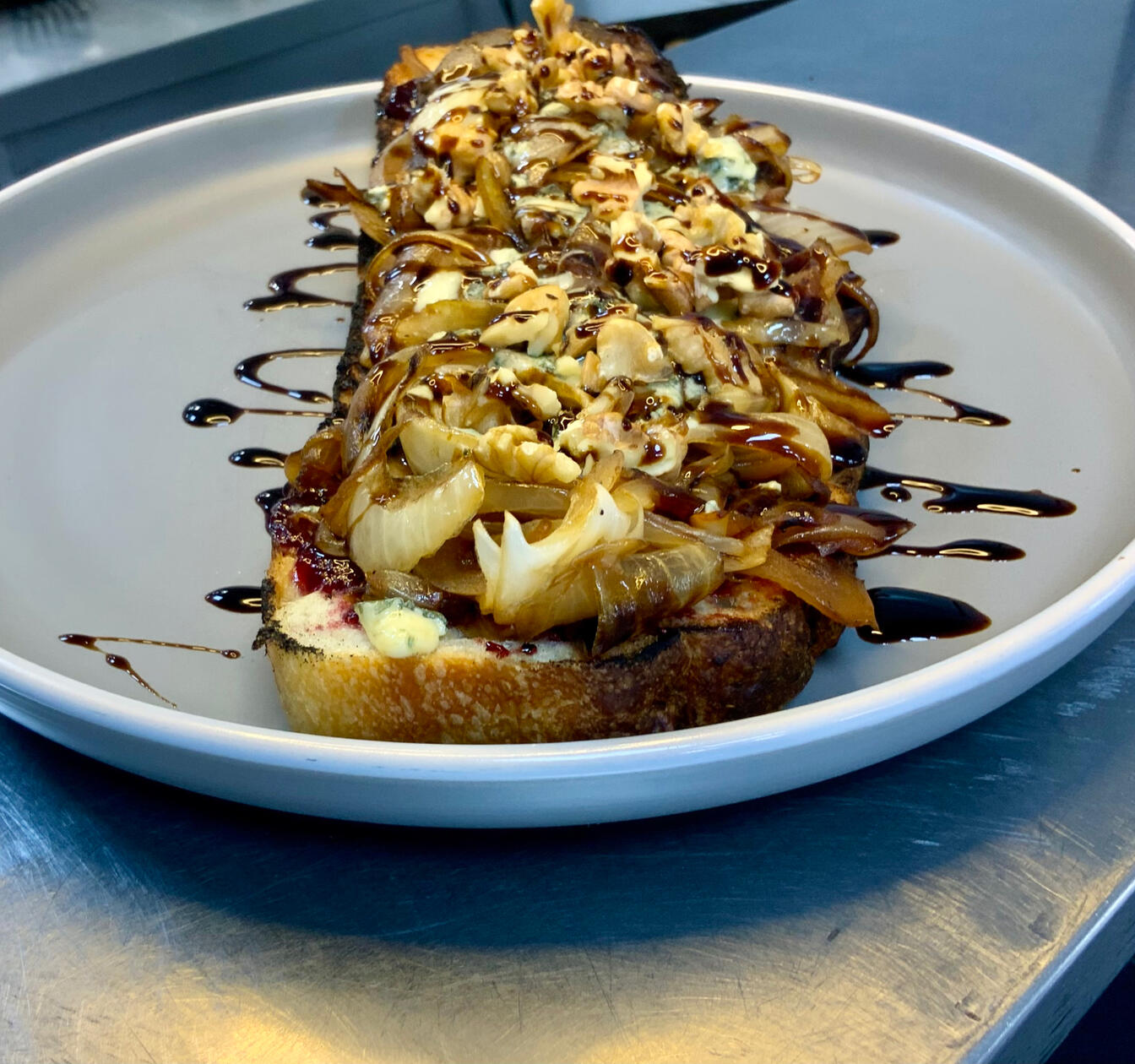 BRUSCHETTA / focaccia, frutos rojos, cebolla caramelizada, queso roquefort, nueces, aceto / $9200